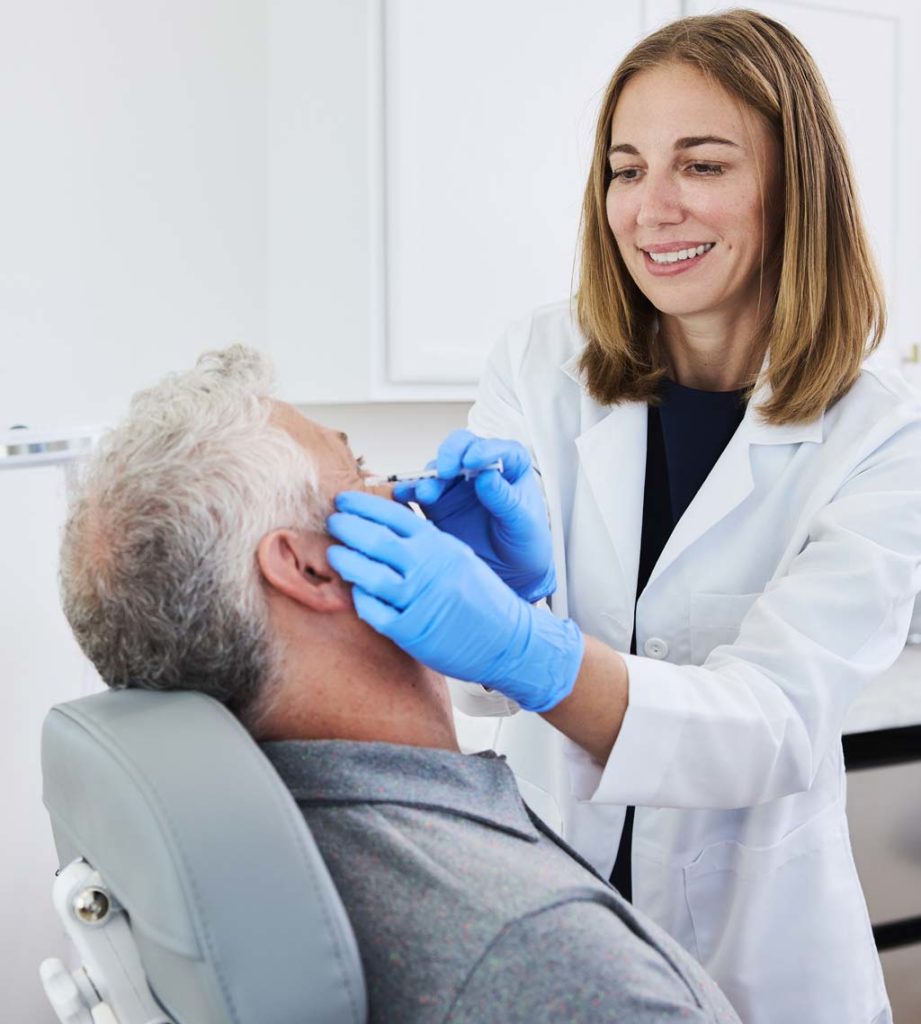 Dr. Jacques gives man a Botox treatment at glo MD Aesthetics and Wellness.