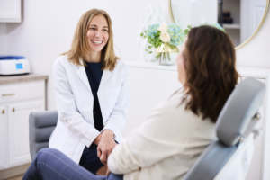 Dr. Jacques warmly converses with a patient during a consultation at in a treatment room Glo MD in Powell, OH.