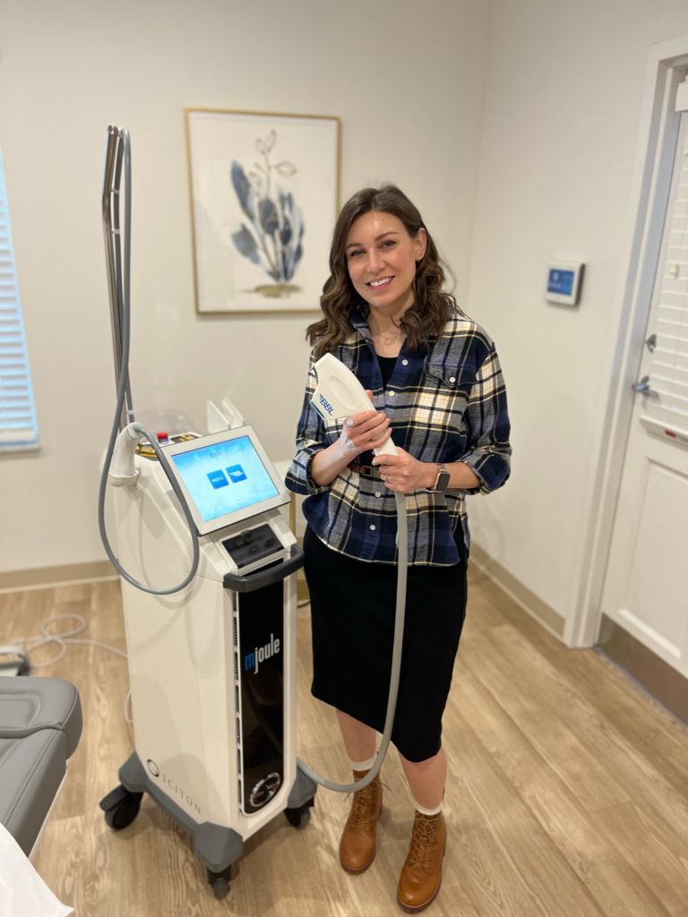 Eve Suiter, LPN, LE stands with laser hair removal machine in treatment room.
